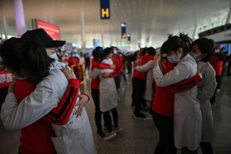Atendentes e enfermeiras de um hospital de Wuhan se abraçam